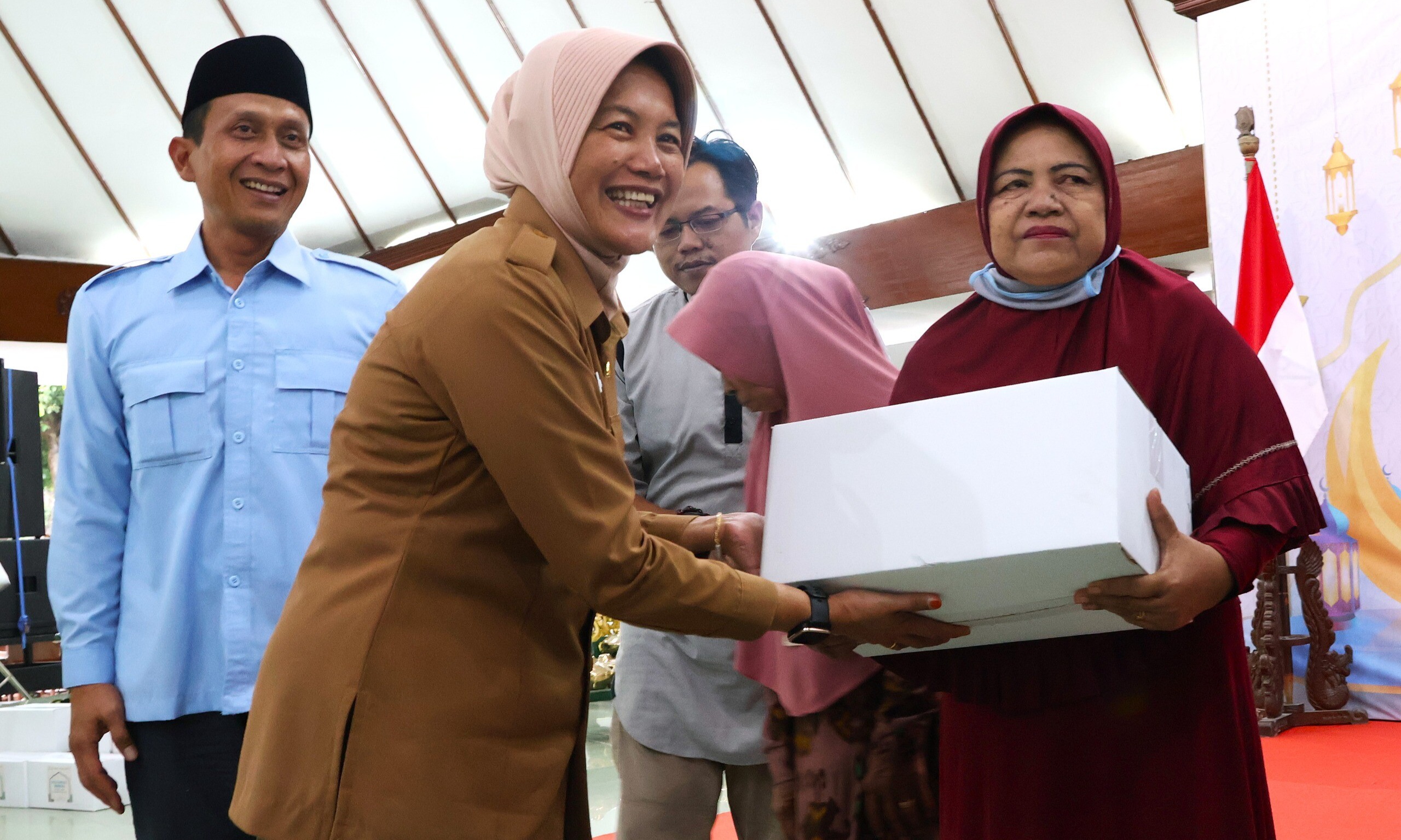 BERBAGI: Wabup Bojonegoro Nurul Azizah saat menyerahkan sembako untuk salah seorang duafa dalam acara santunan yang sugekar Pemkab Bojoengoro dan SKK Migas, Senin (24/3/2025) sore. (Foto: Pemkab Bojonegoro)