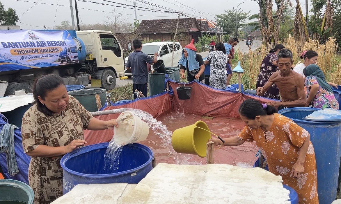 MENGALIRKAN KEBAHAGIAAN: Warga Desa Kasiman saat menerima bantuan air bersih dari Hokpan Keramik, Selasa (27/10/2026). (Foto: Istimewa)