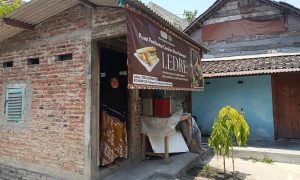 TETAP TRADISIONAL: Mutmainah di pintu dapur produksi ledrenya. Bertahan pakai anglo dan arang. (Foto: Ahmad Wahyu Rizkiawan/Bojonegoro Raya)